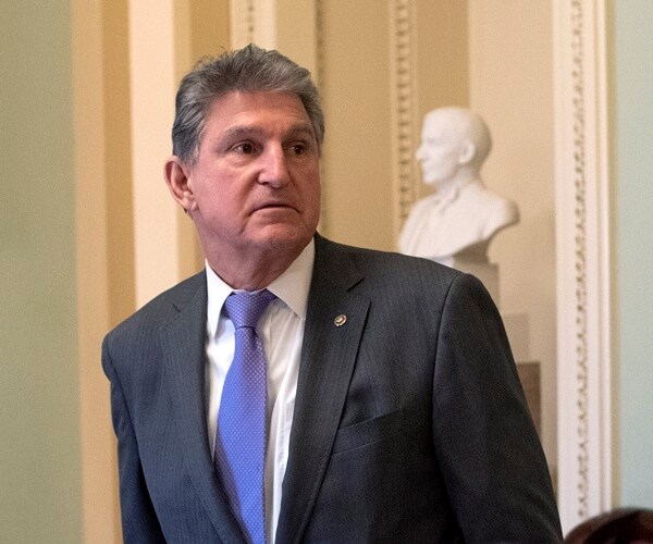 sen. joe manchin stands outside the senate chambers