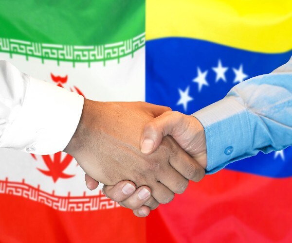 the flags of venezuela and iran in the background with two men shaking hands in front