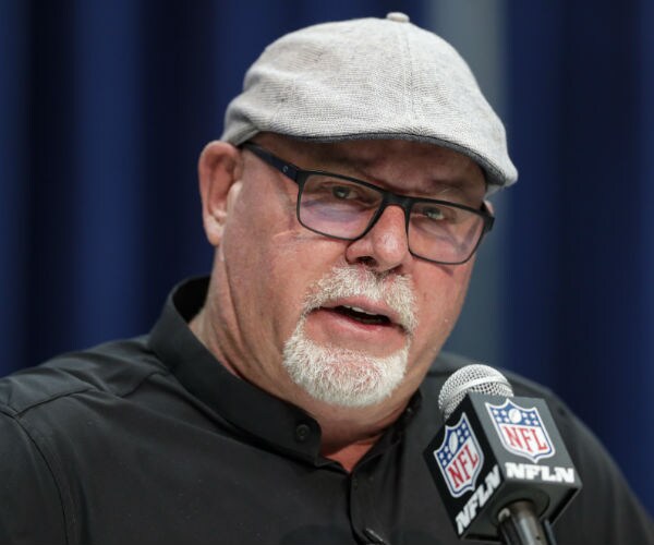 nfl coach bruce arians is seen in a gray hat and black shirt as he addresses the press