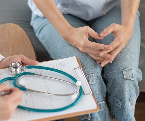 woman talking to doctor in office