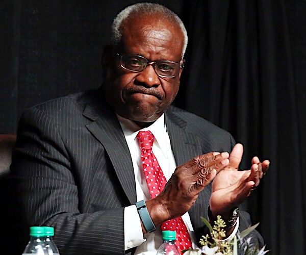 clarence thomas grimaces and applauds at a diner event