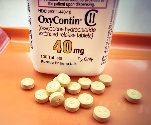 a bottle of oxycontin with pills on a hospital bed tray