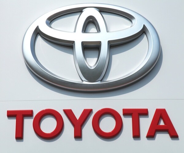 toyota logo in silver is shown with red lettering