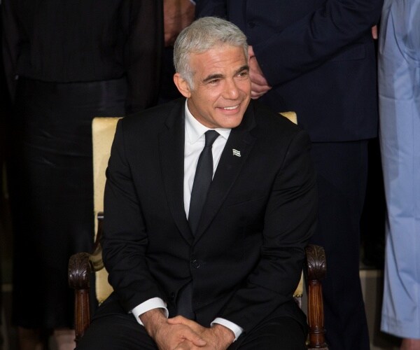 Israel Foreign Minister Yair Lapid sitting in a chair.