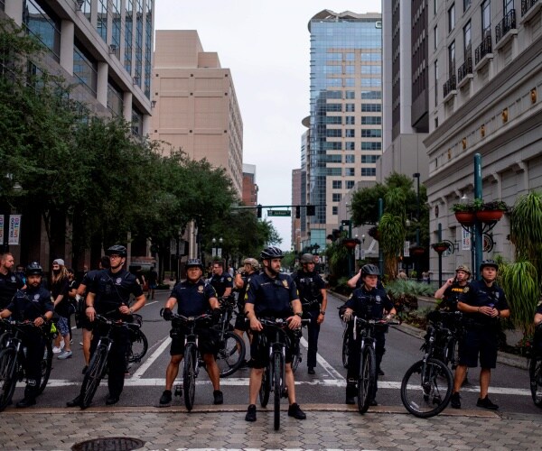 police standing with bicycles in a city center