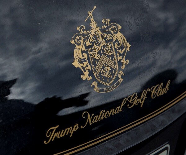 trump national golf club logo in gold on black golf cart