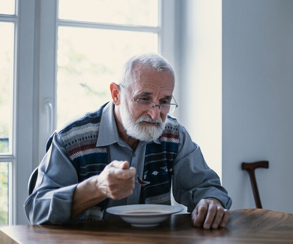 A senior citizen eating alone