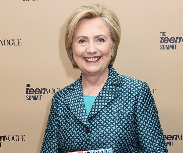 hillary clinton poses at a conference