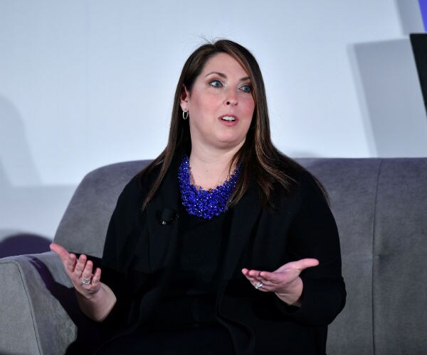 Ronna McDaniel is shown in a black dress with an oversize sapphire blue necklace.
