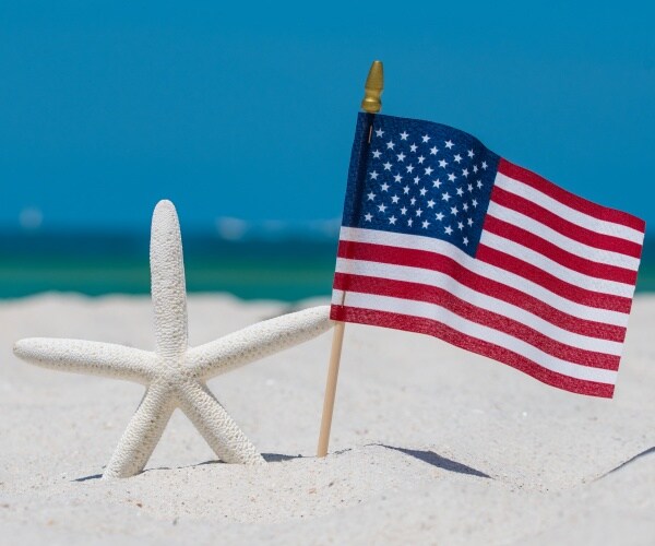 American flag on the beach in sun