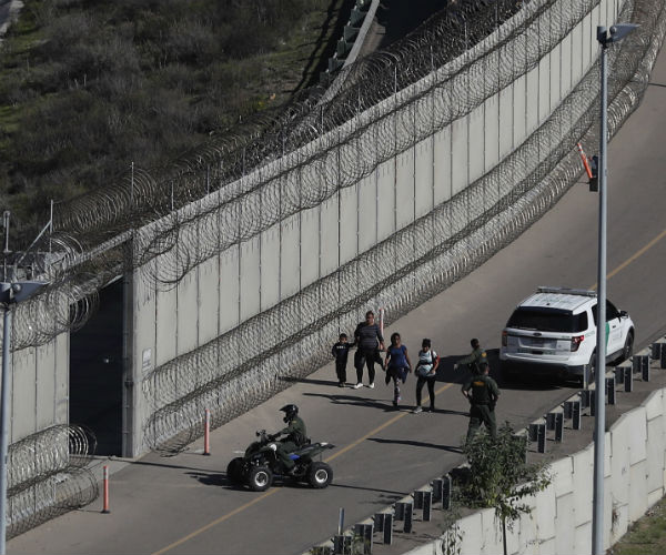 honduran asylum seekers are taken into custody by border patrol agents after the group crossed the u.s. border wall 