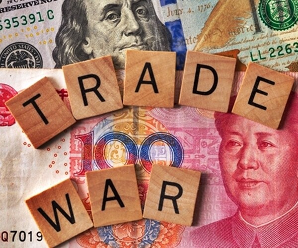 trade war written over 100 usa dollar and 100 chinese yuan banknotes 