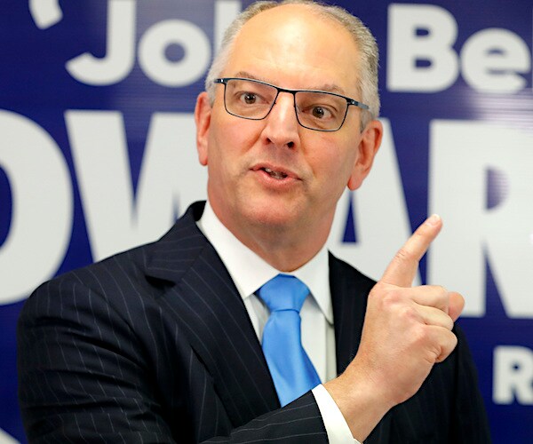 john bel edwards gestures and looks to his right while delivering a campaign speech