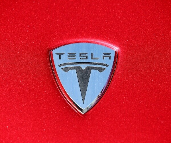 The Tesla Motors logo is seen on the hood of a car