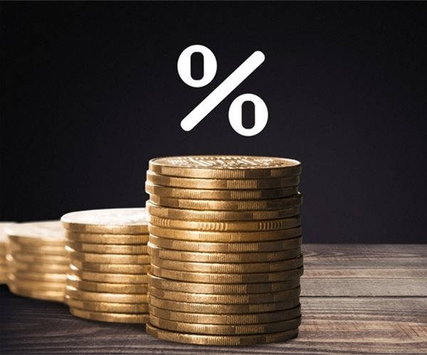 percent sign in white printing above a stack of gold coins against a black background