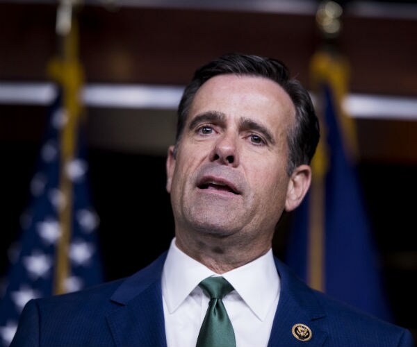 rep. john ratcliffe is shown at a podium with the american flag in the background