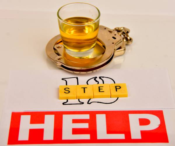illustration  with glass of alcohol inside handcuffs over writing 12 step help