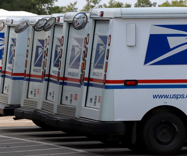 postal trucks lined up in a parking lot