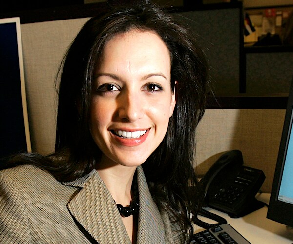 a brunette woman turns around to the camera and smiles