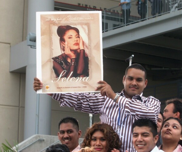 fans of Selena Quintanilla hold up a photo of her