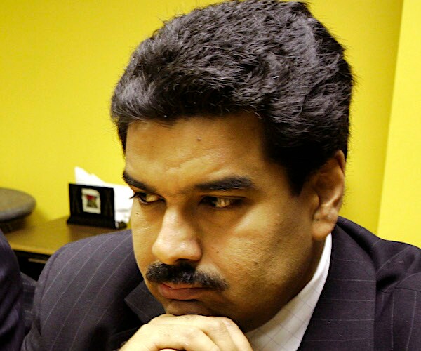 Venezuela's Nicolás Maduro rests his chin on his folded hands