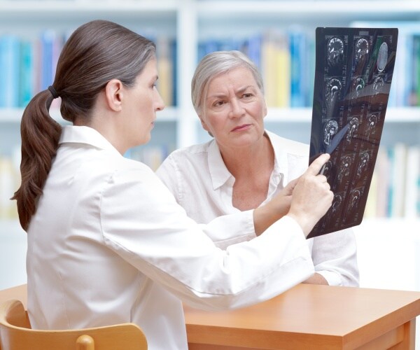 woman looking at brain scans with her doctor
