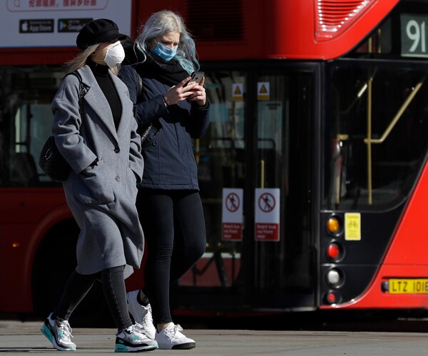 People walking in London wearing masks