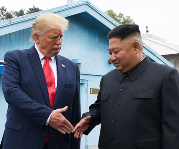 Donald Trump and Kim Jong Un shake hands