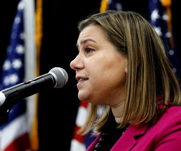 slotkin in a pink coat speaking into a mic