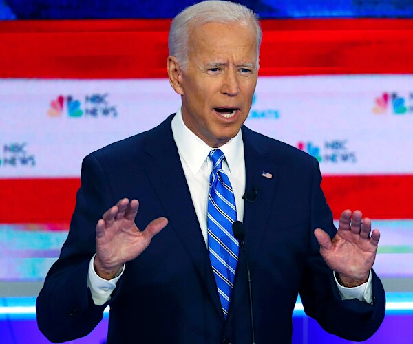 joe biden gestures with both hands during the democratic primary debate