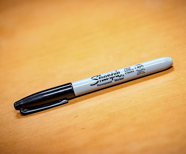 a sharpie lays on a brown table