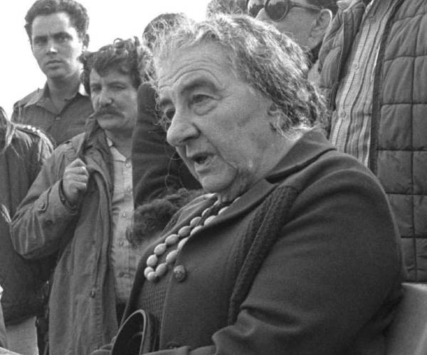 golda meir seated outdoors surrounded by israeli soldiers
