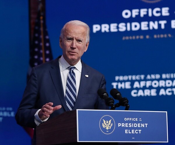 joe biden stands behind podium