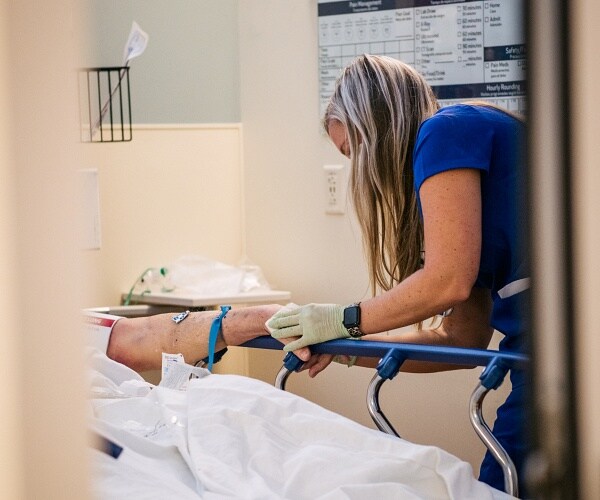 nurse treats patient in er