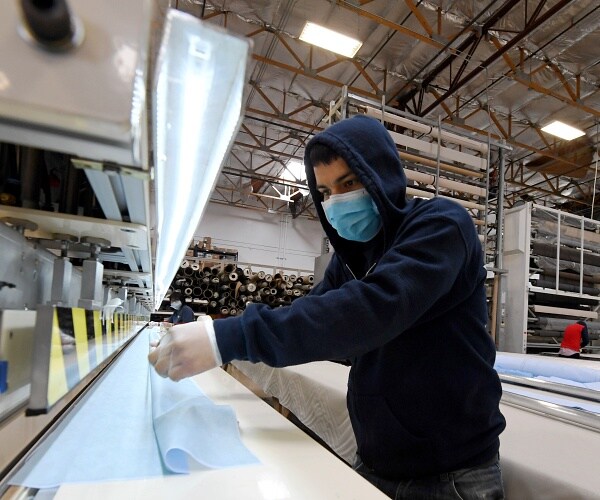 worker makes surgical masks