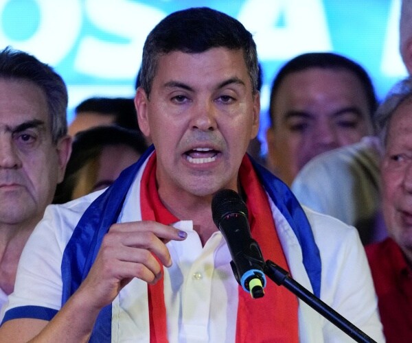 santiago pena speaks into a microphone