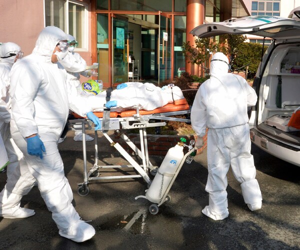 medical workers in south korea transport a patient suspected of having coronavirus