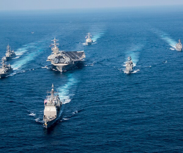 united states naval ships move in unison through the ocean