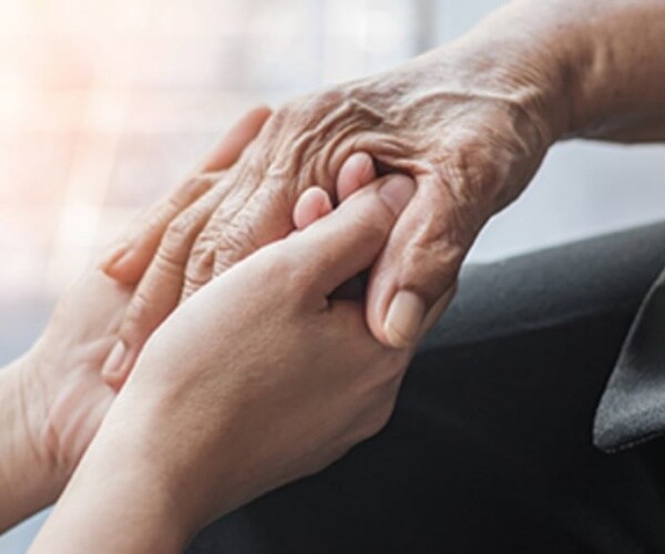 a younger hand holding an older hand