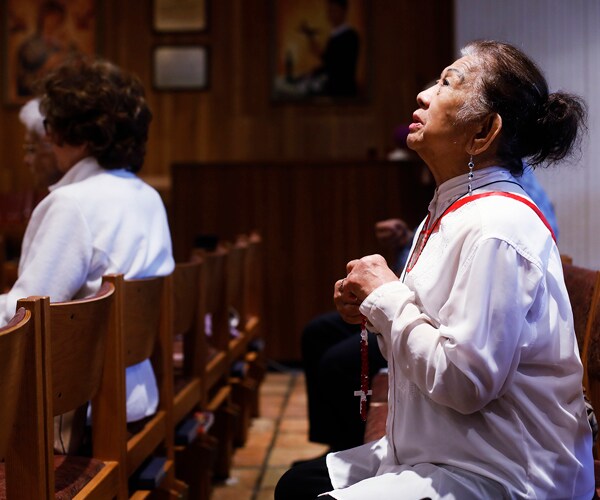 a parishioner in a tampa, florida, catholic church prays for people infected with the coronavirus