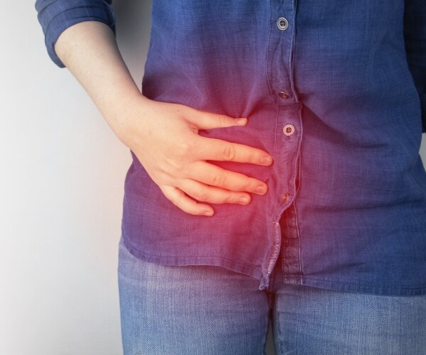 woman holding stomach in pain