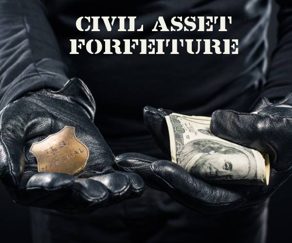 a man dressed in all black with gloves like a thief with a wad of cash in one hand and a police badge in the other
