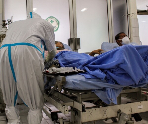 doctor in protective gear caring for patients with severe covid in hospital