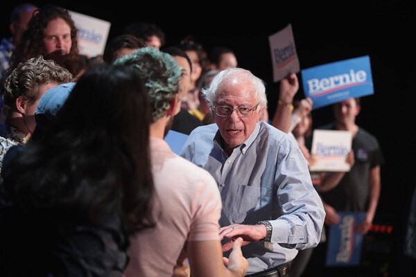 bernie sanders speaks with a supporter at a rally