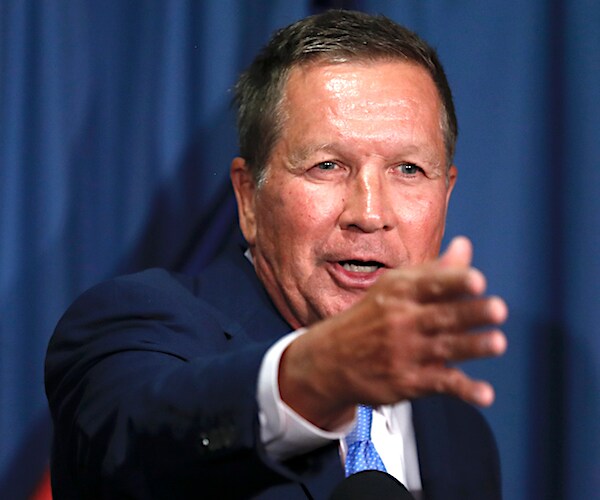 ohio republican governor john kasich points forward with his right hand far in front of his face while speaking