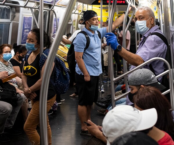 riders on a crowded subway car in new york city