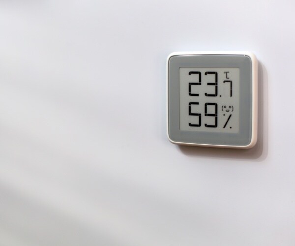 indoor thermometer on wall with temperature/humidity level