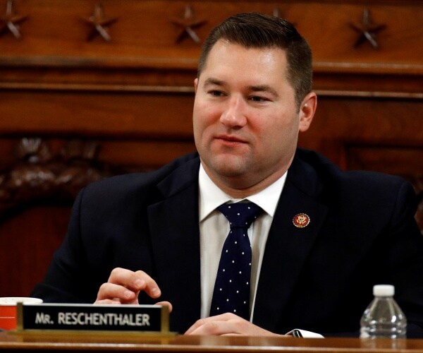 guy reschenthaler in a polka dotted black tie and suit sitting down