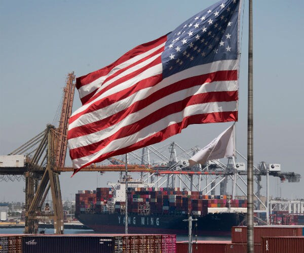 the american flag flies at a port as a chinese ship is seen in the background