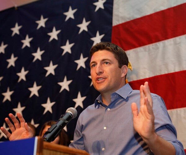 bryan steil campaigning for congress at a podium in front of a flag